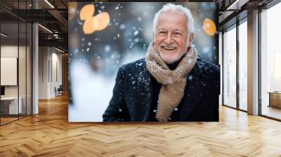 An older gentleman with a gentle smile stands amidst softly falling snow, clad in a dark overcoat and light brown scarf, enjoying the serene winter environment. Wall mural