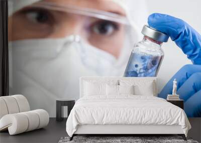 Female doctor or lab scientist holding glass ampoule vial with Coronavirus Wall mural