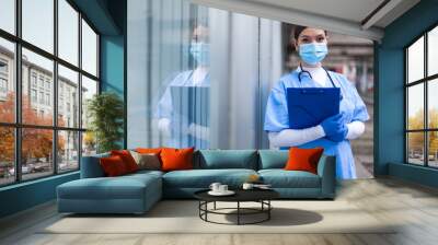 Young female NHS UK EMS doctor in front of healthcare ICU facility Wall mural