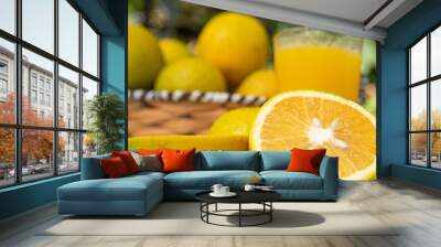 Oranges and orange juice on an old white table with blurred nature in the background, natural light, selective focus. Wall mural