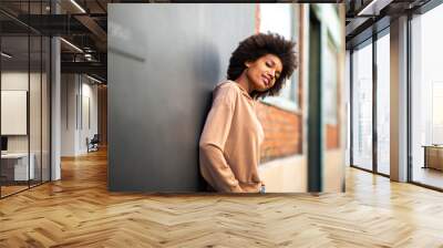 beautiful african american female fashion model leaning against wall Wall mural