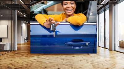 Beautiful black woman sitting in her new car and showing keys Wall mural