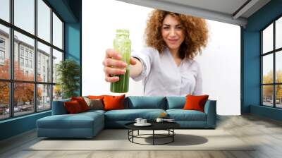 beautiful woman with curly hair holding bottle of green juice Wall mural