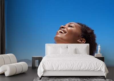 Beautiful young african woman laughing outdoors Wall mural