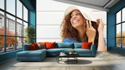 Beautiful young woman laughing and wearing summer hat Wall mural