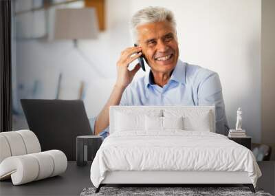 businessman sitting at work talking with mobile phone Wall mural