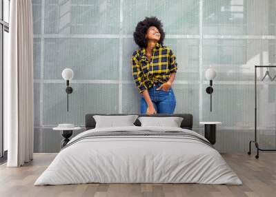 cheerful young black woman laughing and looking up Wall mural