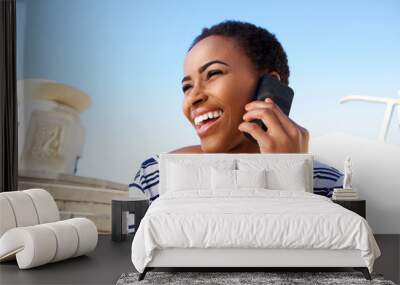 cheerful young black woman listening to cell phone Wall mural