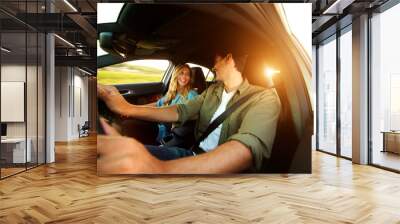 Close up beautiful couple laughing in car on road trip Wall mural