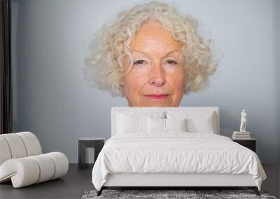 Close up beautiful older woman against white background Wall mural