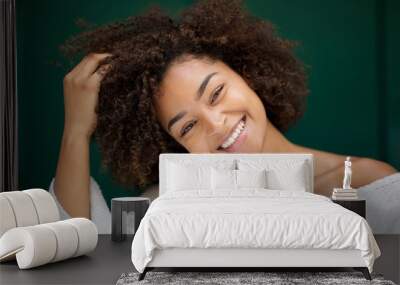 Close up beautiful young african american woman smiling with hand in hair Wall mural