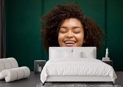 Close up front of young smiling african american woman with curly hair Wall mural