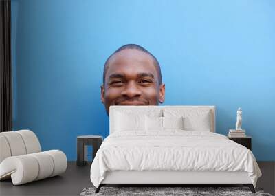 Close up happy young black man against blue background Wall mural