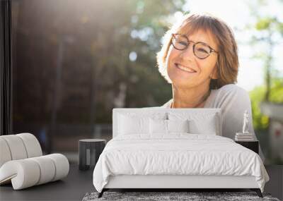 Close up older woman with eyeglasses smiling outside Wall mural