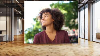 Close up smiling african American girl with curly hair looking away Wall mural