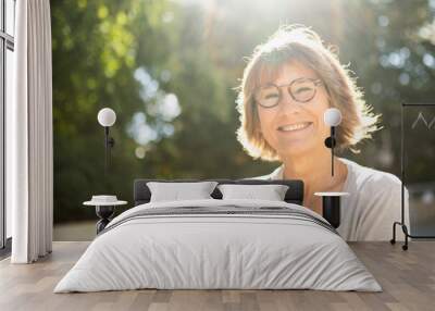 Close up smiling older woman outside with glasses Wall mural