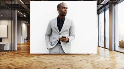 cool African American business man standing with cellphone by white wall Wall mural