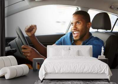 Excited young african american man driving a car Wall mural