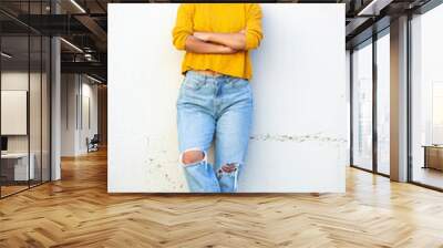 Full body smiling young woman standing by white wall with arms crossed Wall mural