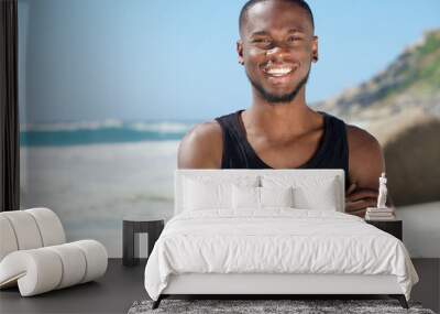 Handsome cheerful man smiling at the beach Wall mural