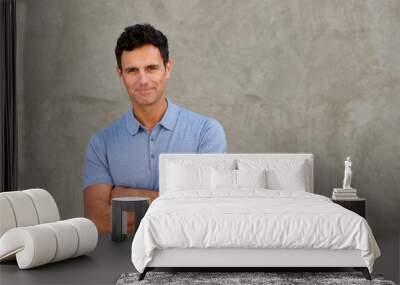 handsome man standing by wall with arms crossed Wall mural