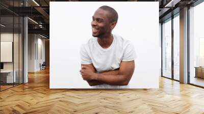 happy african american man laughing with arms crossed and looking away against white background Wall mural