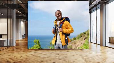 happy african american man with backpack in nature Wall mural