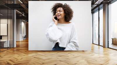 happy african american woman talking with mobile phone by white background Wall mural