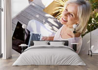 happy older woman with laptop computer sitting outside Wall mural