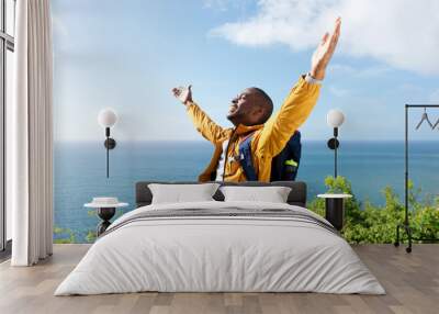 happy young african american male traveler with arms open outdoors Wall mural