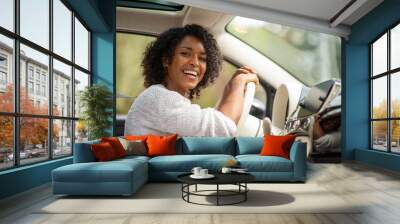 happy young african american woman driving in car Wall mural