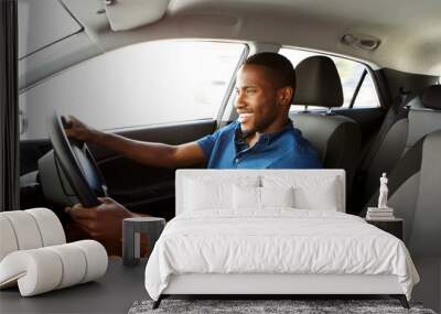 Happy young african man driving a car Wall mural