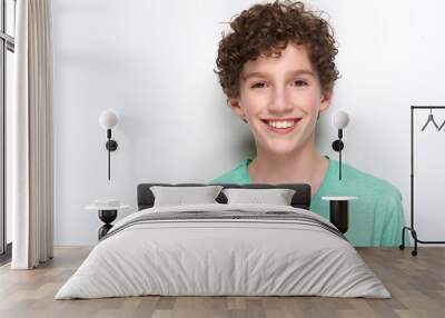 Happy young boy with curly hair smiling Wall mural