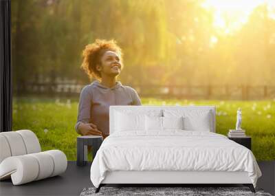 Happy young woman sitting in yoga position Wall mural