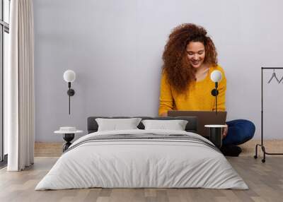 happy young woman sitting on floor with laptop Wall mural