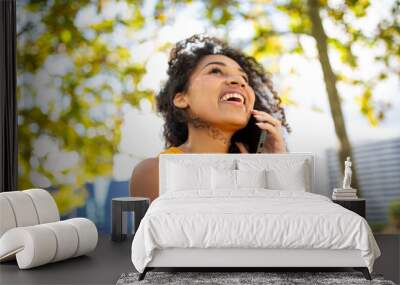 happy young woman talking with cellphone outdoor Wall mural