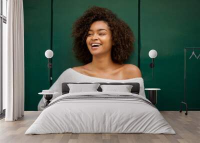 laughing young african american woman against green background Wall mural