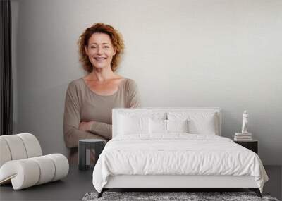 Older woman smiling with arms crossed by wall Wall mural