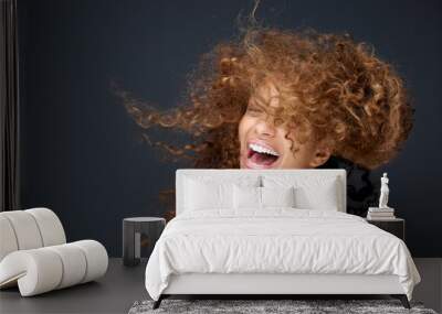 Portrait of a happy young woman laughing with hair blowing Wall mural