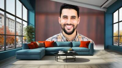 Portrait of handsome young arabic man smiling Wall mural