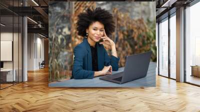 smiling african american businesswoman sitting with laptop computer Wall mural