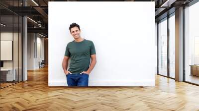 smiling middle age man leaning against white wall Wall mural