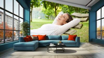 Smiling older woman relaxing on hammock outdoors Wall mural