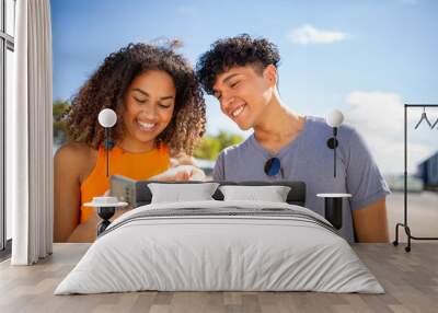 smiling young couple looking at phone Wall mural