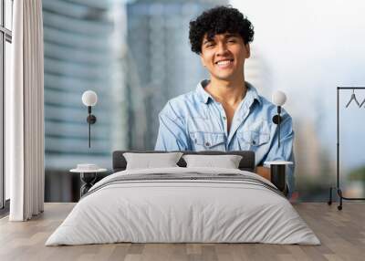 smiling young guy in city with arms crossed Wall mural