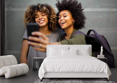 two young african american friends taking selfie with mobile phone Wall mural