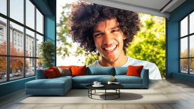 young North African man with afro hair laughing outside Wall mural