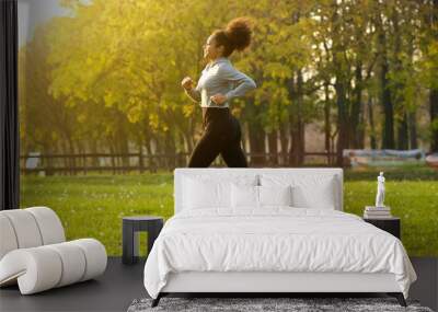 Young woman running outdoors Wall mural