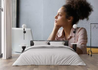 Young working woman looking out window Wall mural