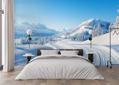 Snow-covered mountain road with a clear blue sky, winter adventure Wall mural